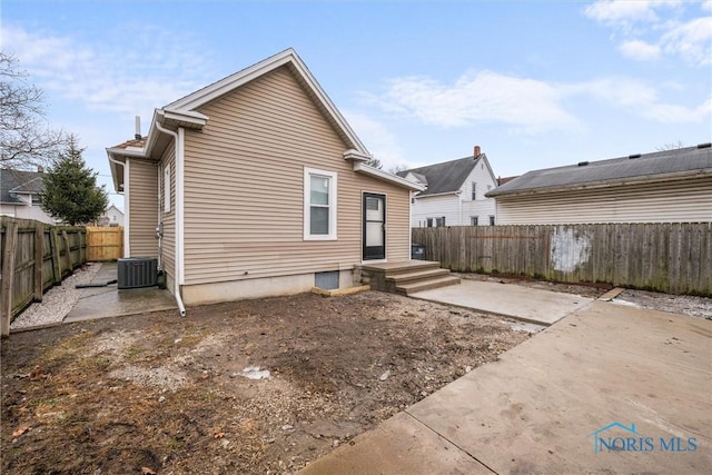 rear view of house featuring a patio area, a fenced backyard, and central air condition unit