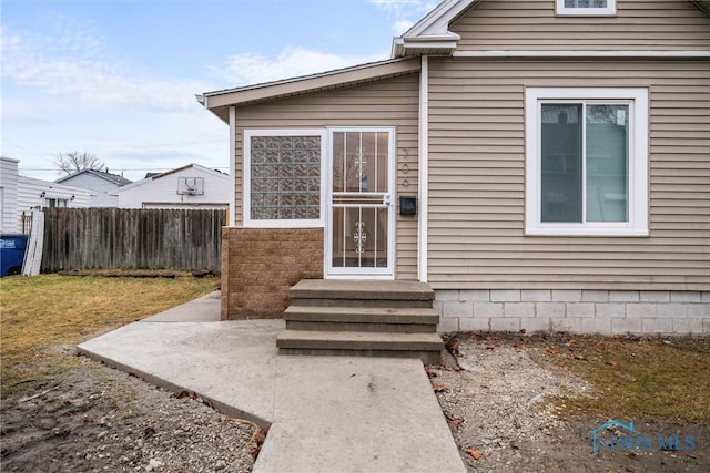 view of exterior entry featuring fence