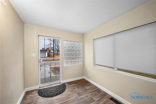 entryway featuring baseboards, visible vents, and wood finished floors