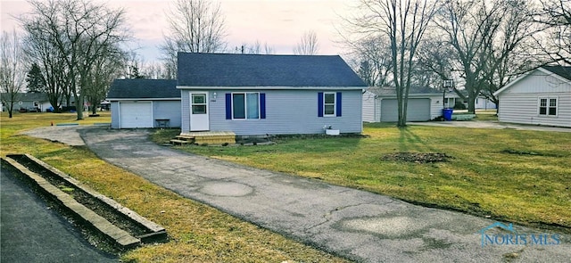 view of front of house with an attached garage, driveway, a front lawn, and roof with shingles