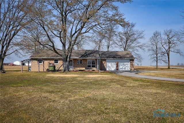 view of front of house featuring brick siding, an attached garage, driveway, and a front lawn