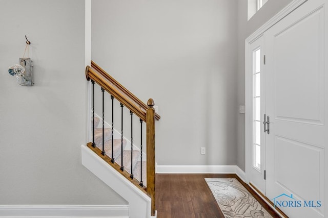 entryway featuring stairs, baseboards, a wealth of natural light, and wood finished floors