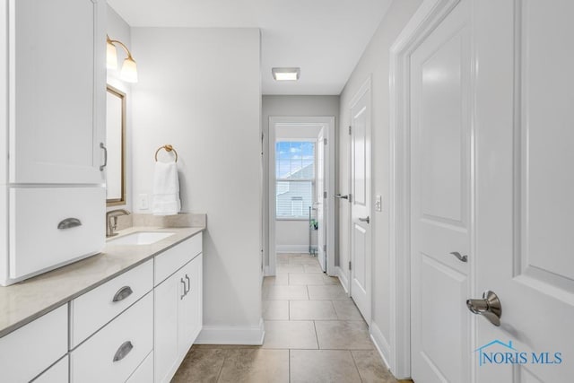 bathroom with vanity, baseboards, and tile patterned floors