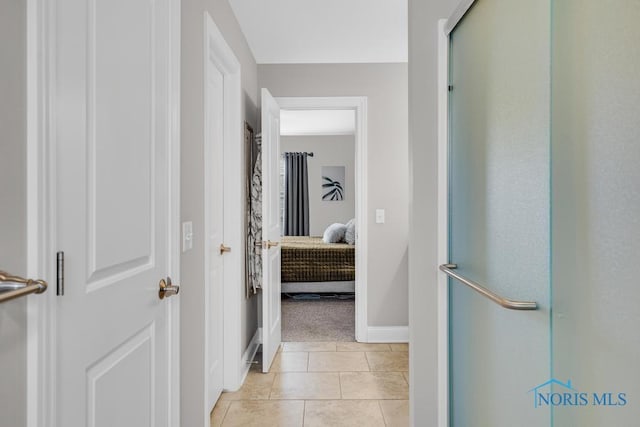 full bathroom featuring ensuite bathroom, baseboards, a shower with door, and tile patterned floors