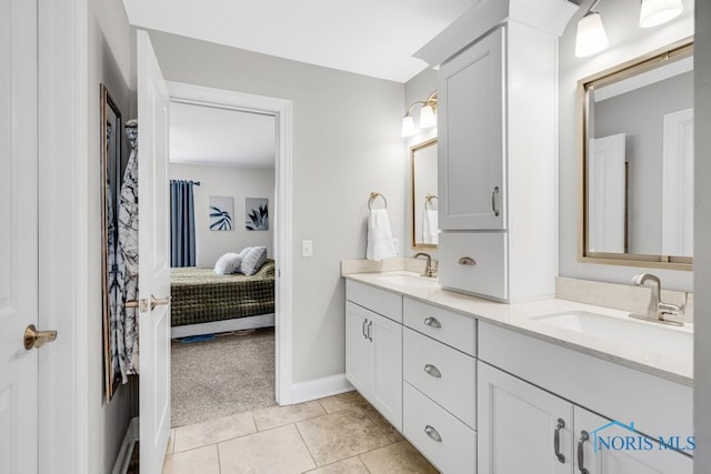 bathroom featuring double vanity, a sink, ensuite bathroom, and tile patterned floors