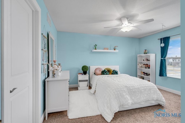 carpeted bedroom featuring ceiling fan and baseboards