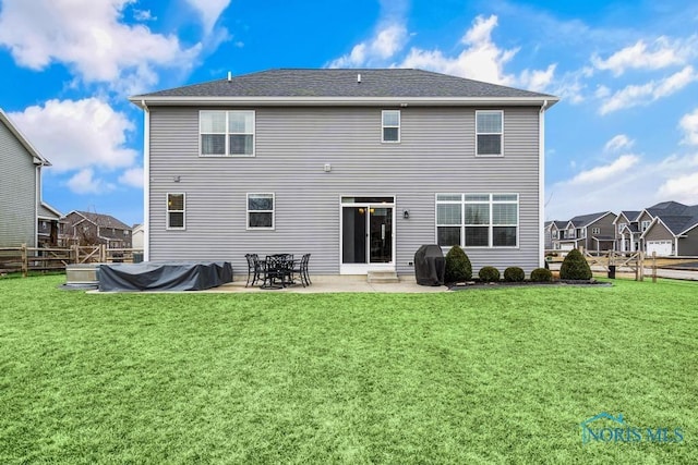 rear view of house featuring a patio area, a lawn, and fence