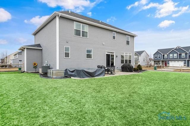 rear view of house with cooling unit, a lawn, fence, and a patio