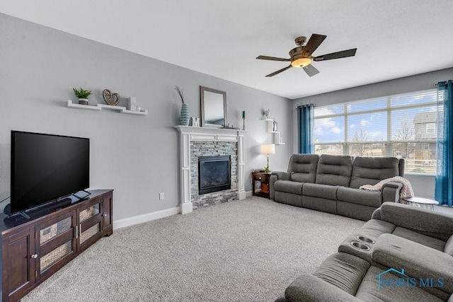 living area with carpet floors, a fireplace, baseboards, and ceiling fan