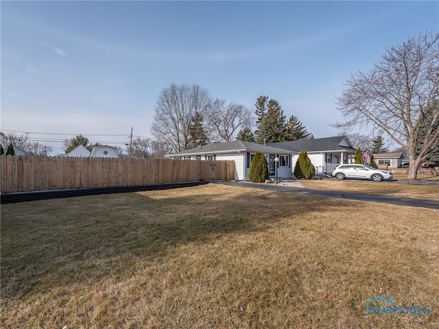 view of front of home with a front lawn and fence