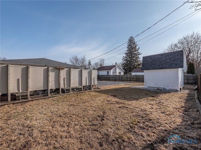 view of yard with an outbuilding, a shed, and a fenced backyard