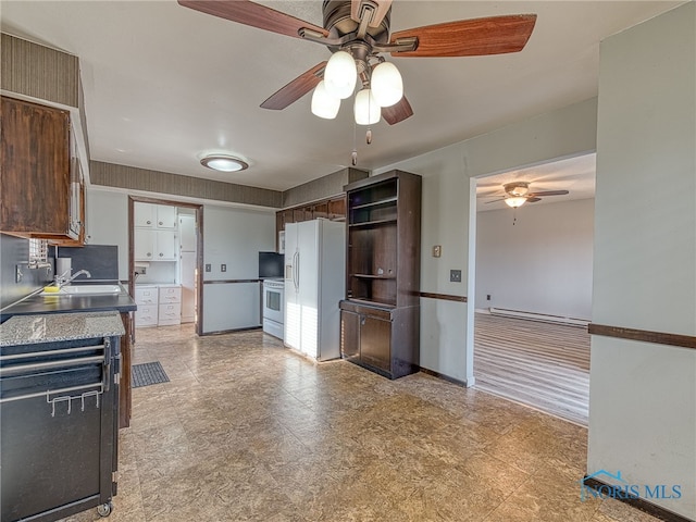 kitchen featuring dark brown cabinetry, white appliances, baseboards, open shelves, and a sink