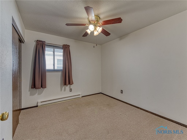 unfurnished room with a baseboard heating unit, a textured ceiling, carpet flooring, and baseboards