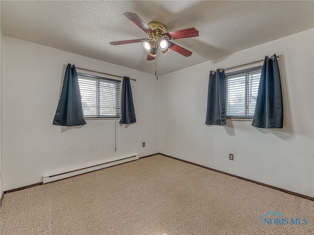 unfurnished room featuring a baseboard radiator, a healthy amount of sunlight, a textured ceiling, and carpet