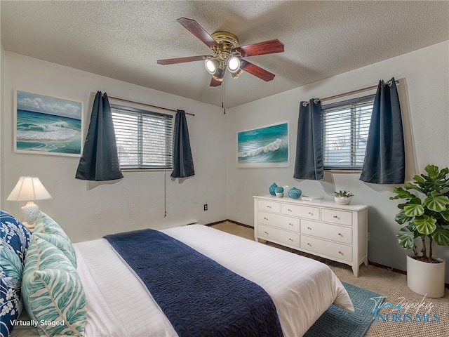 bedroom featuring a textured ceiling, multiple windows, a ceiling fan, and light colored carpet