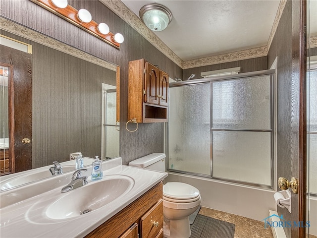 bathroom with toilet, wallpapered walls, shower / bath combination with glass door, and vanity