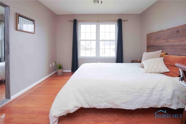 bedroom with light wood-style flooring and baseboards