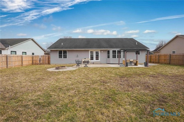 back of house with a patio area, a fenced backyard, an outdoor fire pit, and a lawn