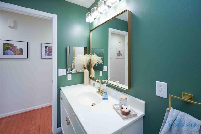 bathroom featuring vanity, baseboards, and wood finished floors