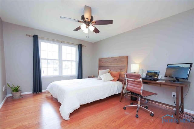 bedroom featuring a ceiling fan, baseboards, and wood finished floors