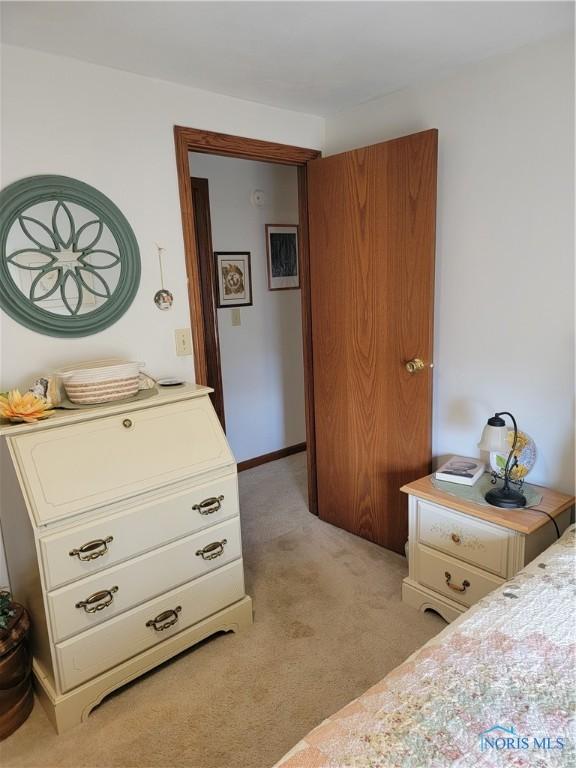 bedroom featuring light colored carpet and baseboards