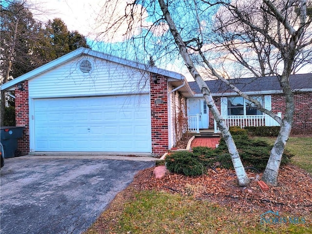 single story home featuring a garage, driveway, and brick siding