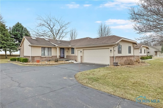 ranch-style home with brick siding, a shingled roof, a front yard, a garage, and driveway