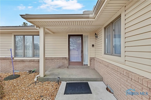 entrance to property featuring brick siding