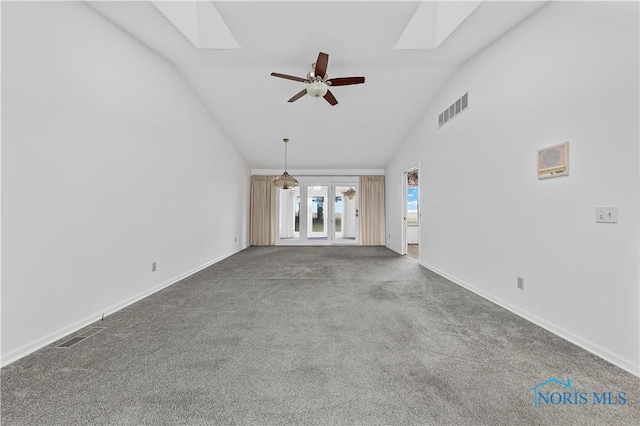 unfurnished living room with a skylight, visible vents, ceiling fan, and carpet flooring