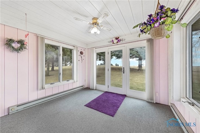 unfurnished sunroom with a baseboard heating unit, baseboard heating, a wealth of natural light, and a ceiling fan