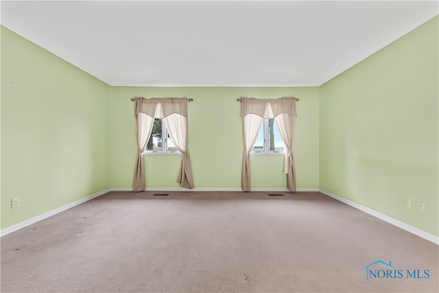 carpeted empty room featuring baseboards