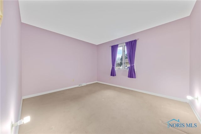 carpeted empty room with visible vents and baseboards