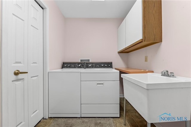 laundry area featuring cabinet space, a sink, and washing machine and clothes dryer