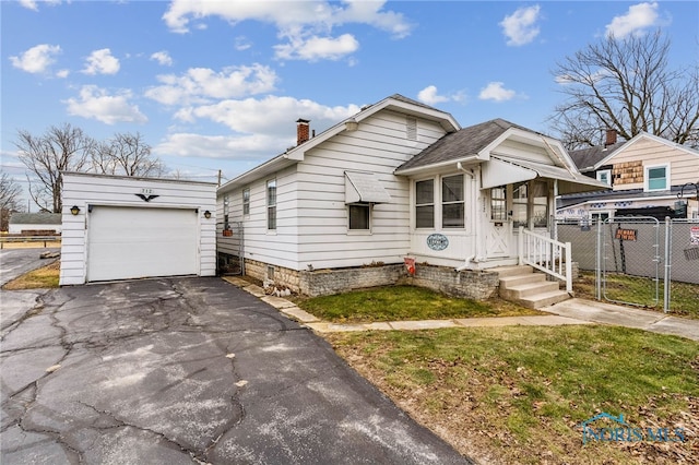 view of front of house featuring an outbuilding, a garage, fence, driveway, and a chimney