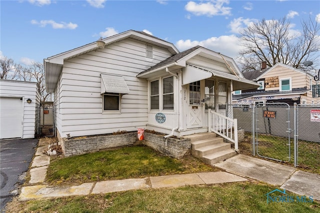 view of front of home with a gate, fence, and roof with shingles