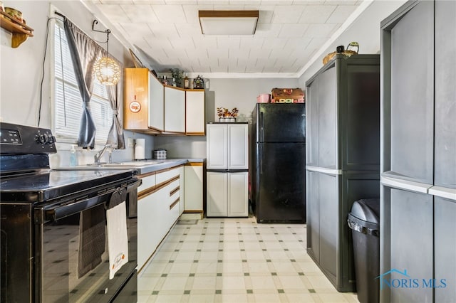 kitchen featuring light floors, a sink, white cabinets, light countertops, and black appliances