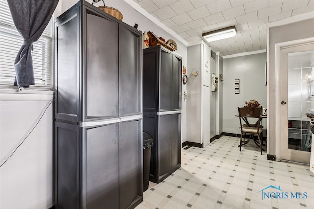 kitchen featuring ornamental molding, light countertops, baseboards, and light floors