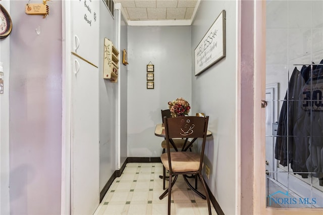 hall with baseboards and light floors