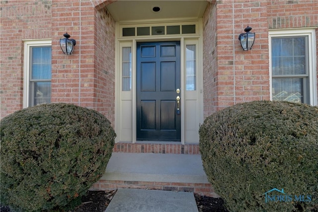 entrance to property featuring brick siding