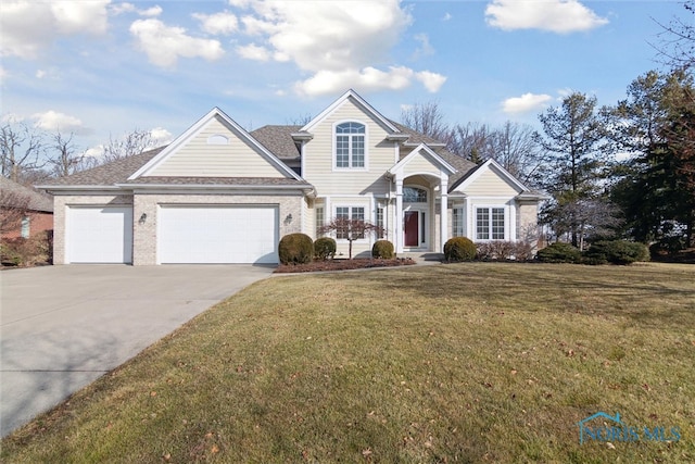 traditional-style home with driveway, brick siding, an attached garage, and a front yard