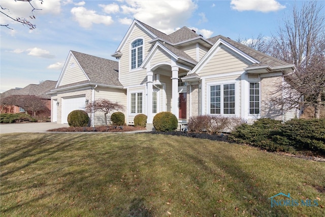 traditional home with driveway, a front lawn, an attached garage, and a shingled roof