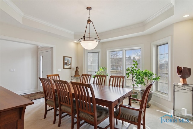 dining area featuring ornamental molding, a tray ceiling, and baseboards