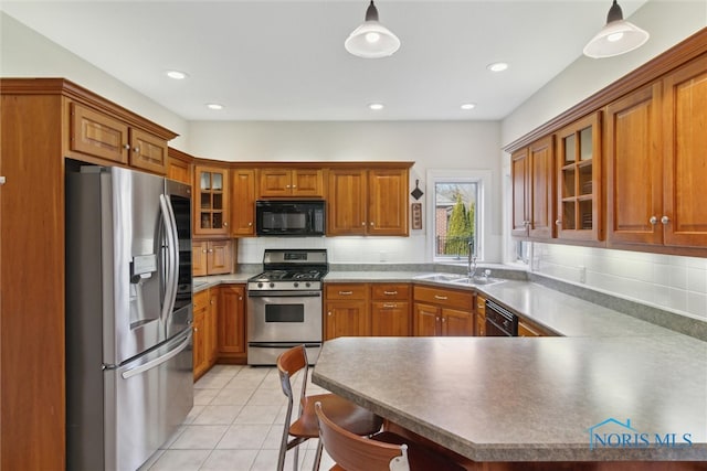 kitchen featuring tasteful backsplash, brown cabinetry, light tile patterned flooring, a sink, and black appliances