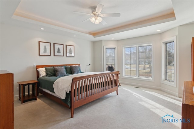 carpeted bedroom with baseboards, a raised ceiling, a ceiling fan, and recessed lighting