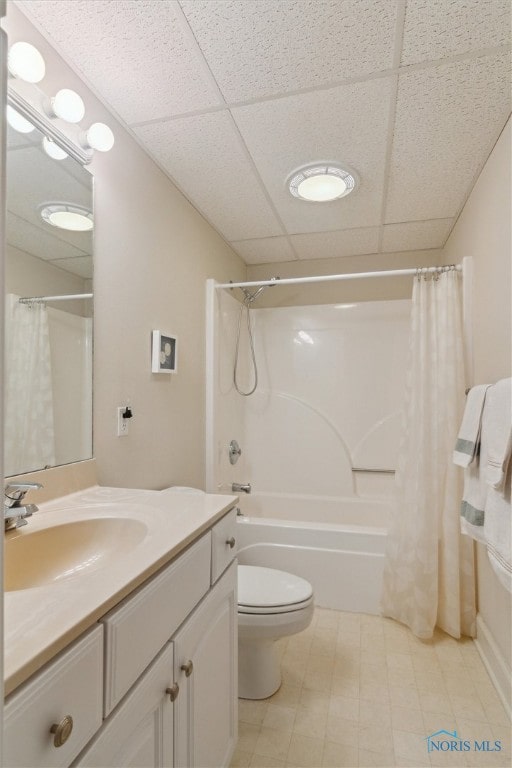 full bathroom with shower / bath combo, a drop ceiling, vanity, and toilet