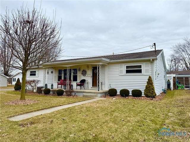 ranch-style house featuring covered porch and a front lawn