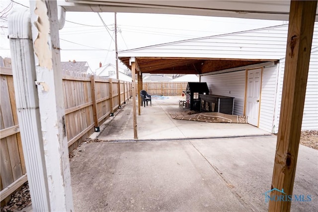 view of patio / terrace with a carport, a fenced backyard, and driveway