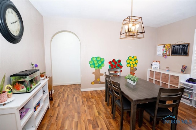 dining room featuring a notable chandelier, light wood-style flooring, and baseboards