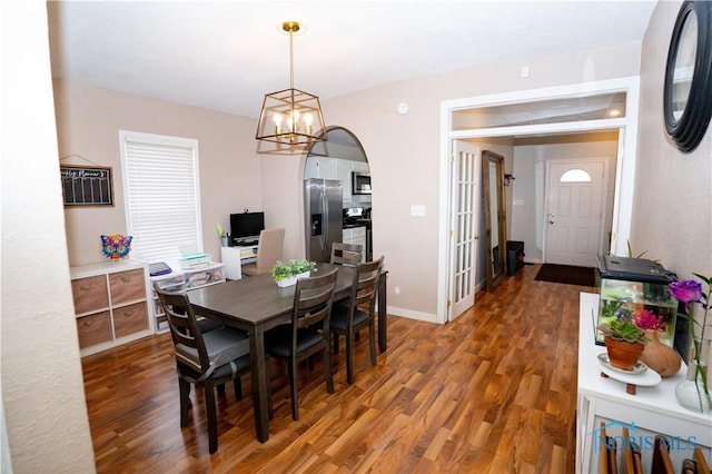 dining room with a chandelier, baseboards, and wood finished floors