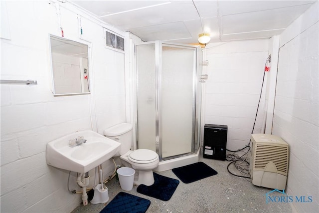 full bath featuring concrete block wall, visible vents, a shower stall, and toilet